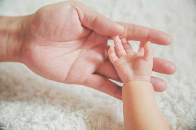 Father Touching Baby Finger