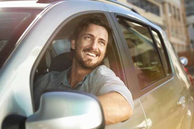 Young man looking out of car window